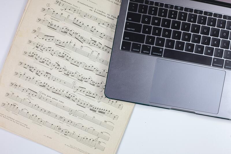 Picture of a music score and a mac computer
